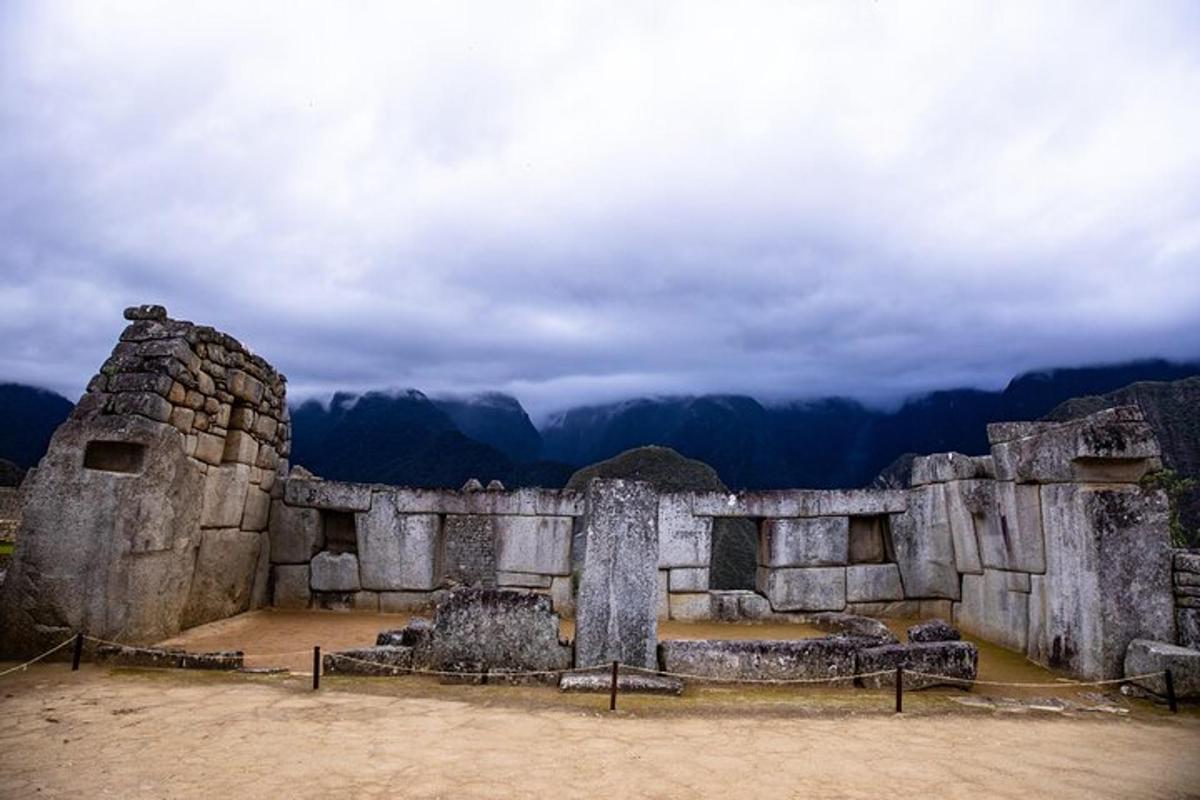 a large stone building with mountains in the background