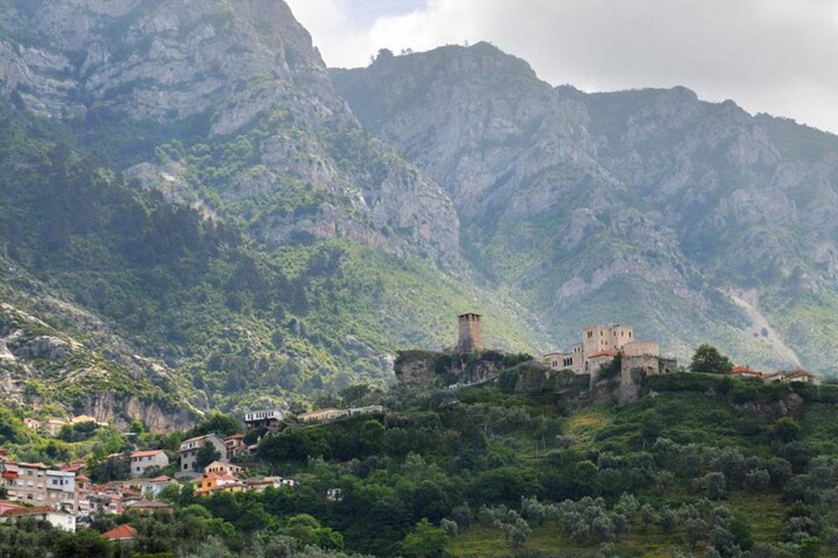 un poble dalt d'un turó amb muntanyes al fons