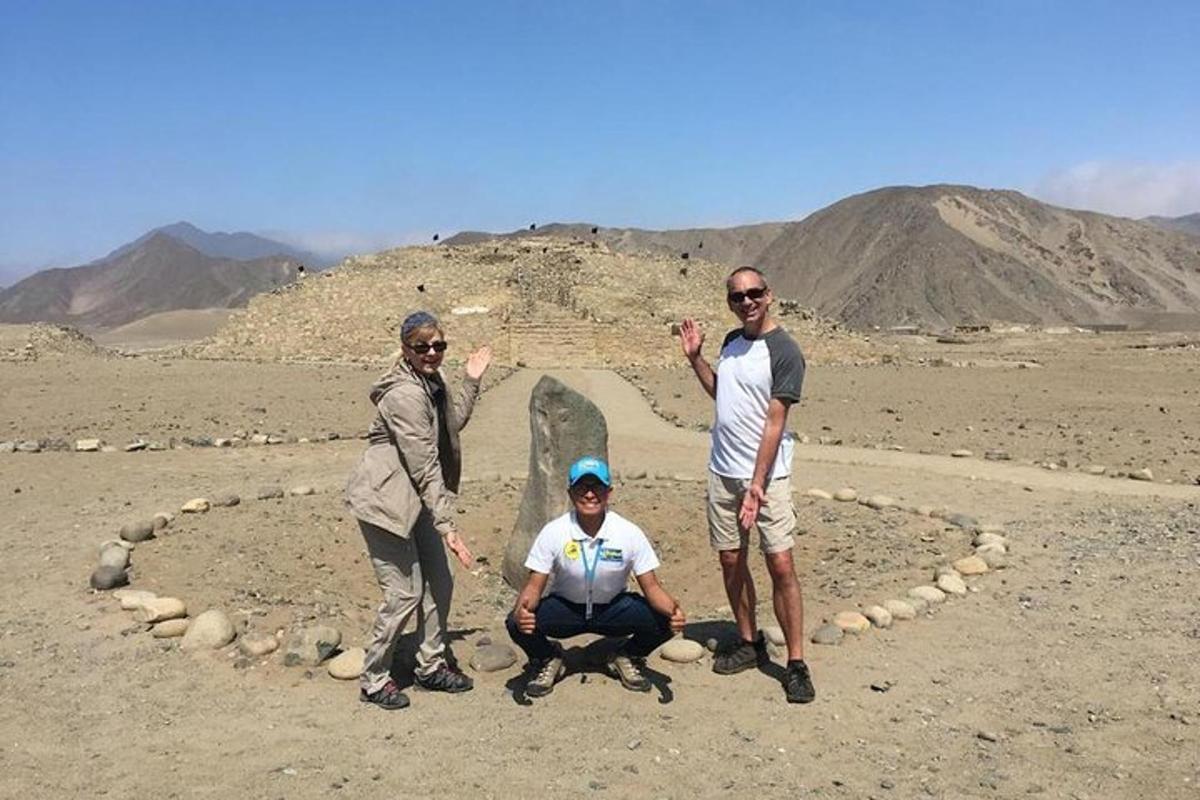 três homens em pé em frente a um círculo de pedras no deserto