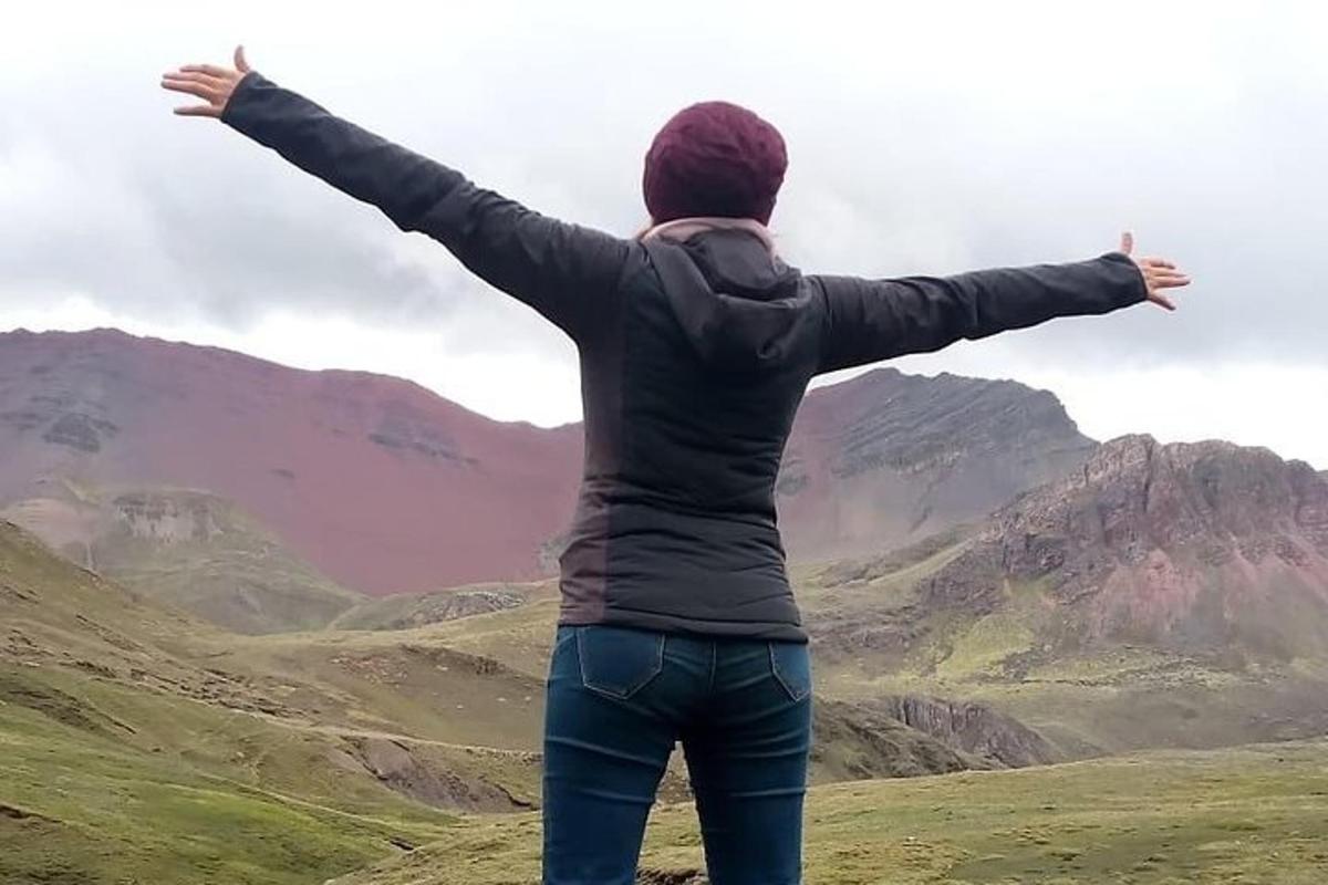 a person standing on top of a mountain with their arms outstretched