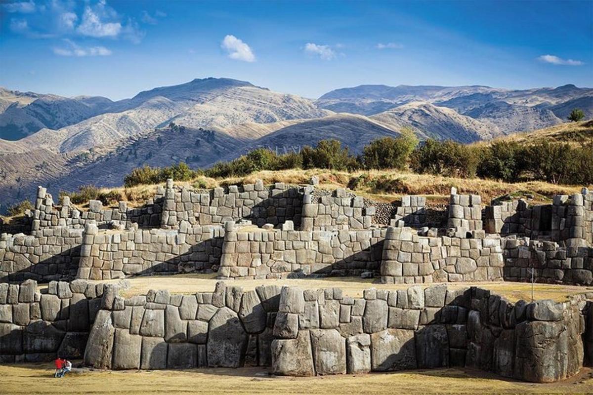 a large stone wall with mountains in the background