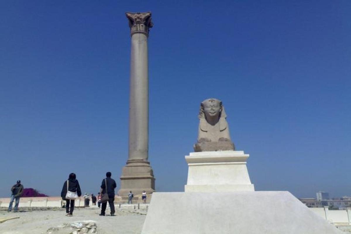 una statua davanti a una colonna e un monumento