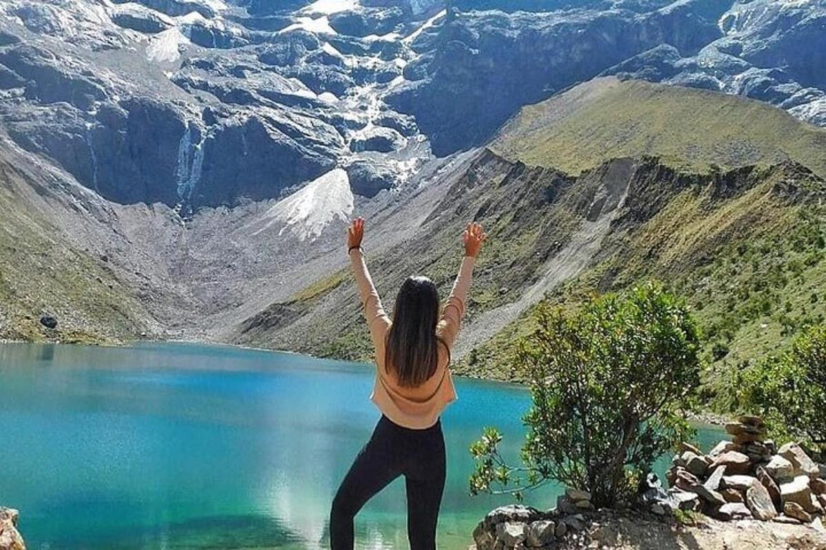 una donna che fa yoga vicino a un lago di montagna