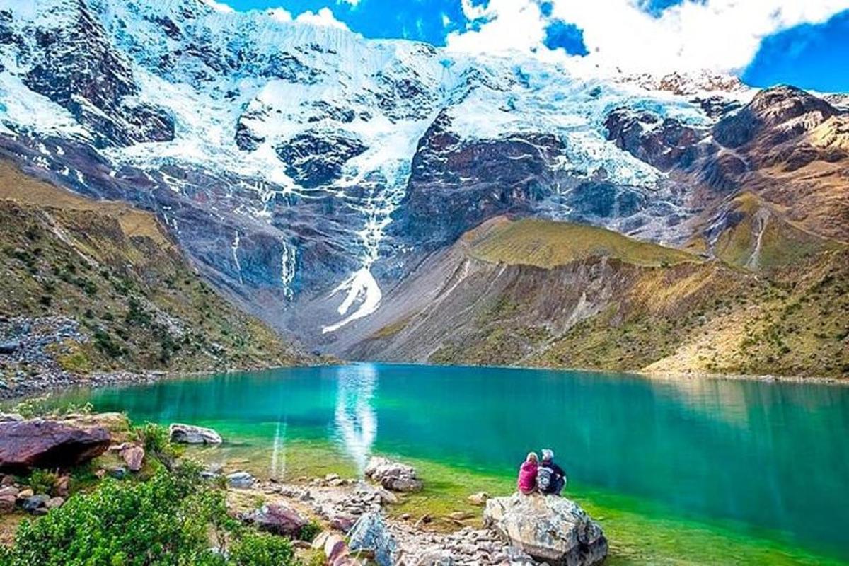 due persone sedute su una roccia vicino a un lago di montagna