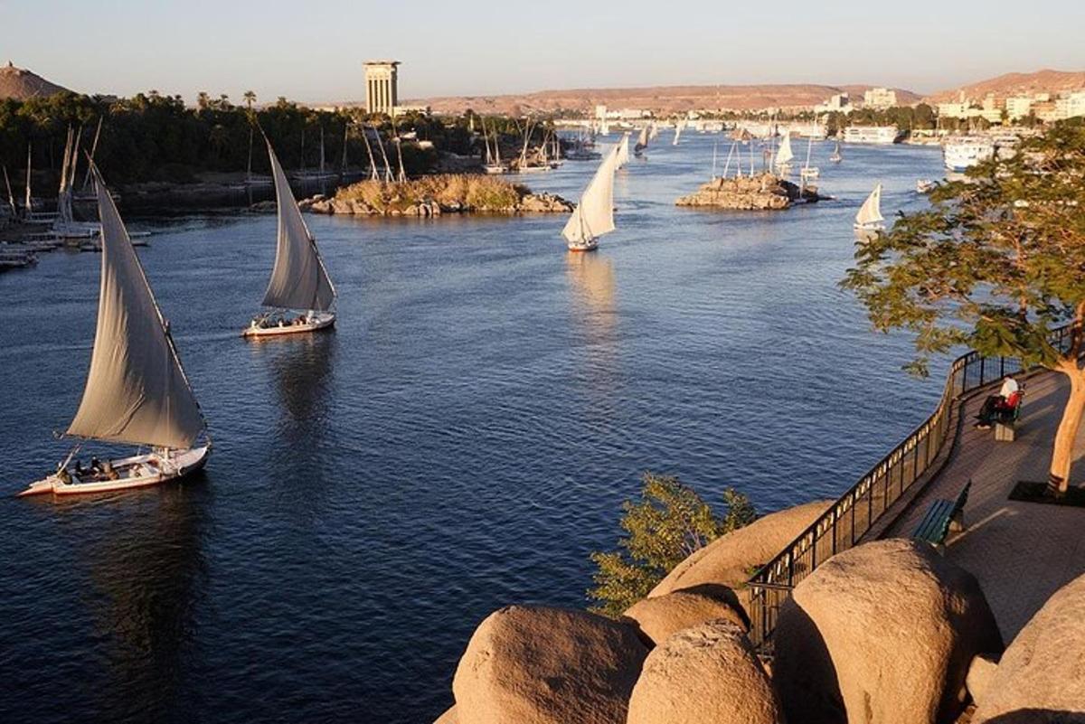 um grupo de barcos navegando em um rio com pedras