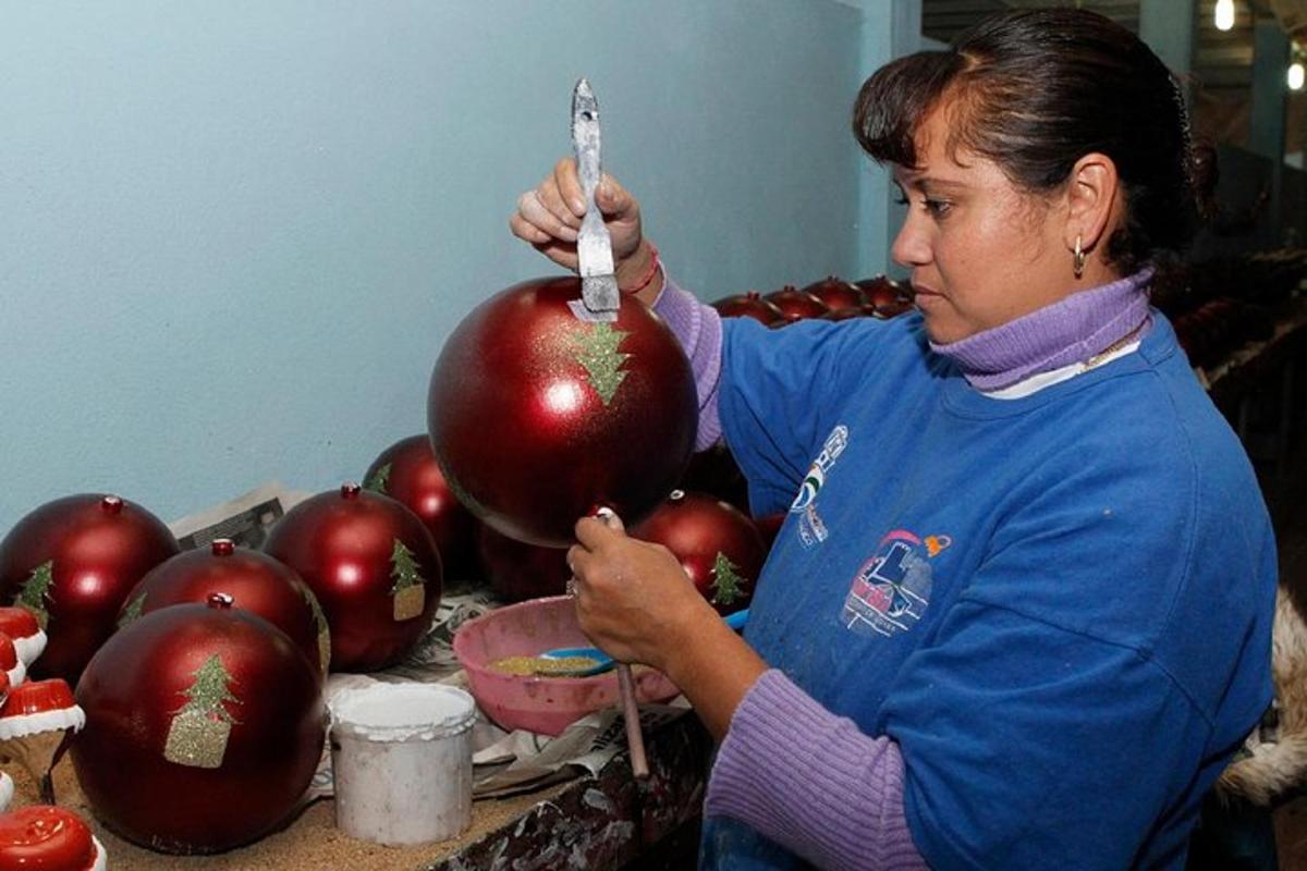 a woman is standing next to a pile of red apples
