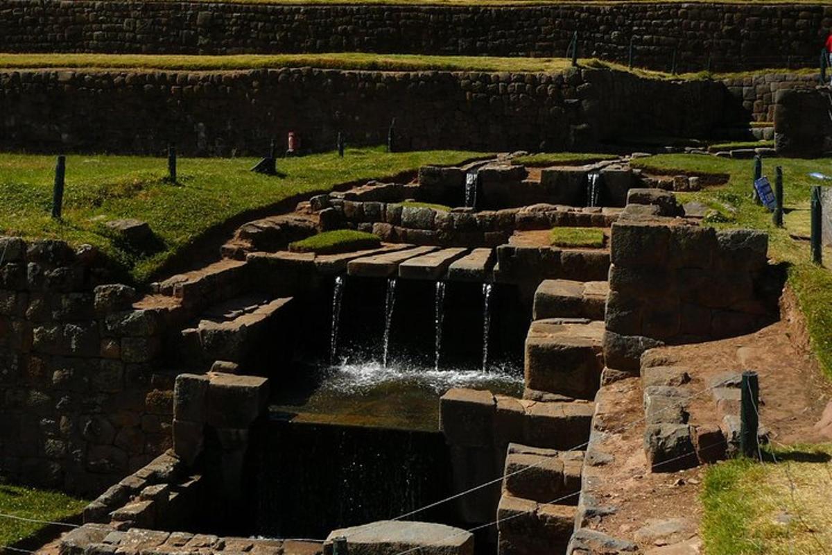 un muro di pietra con una cascata in un campo