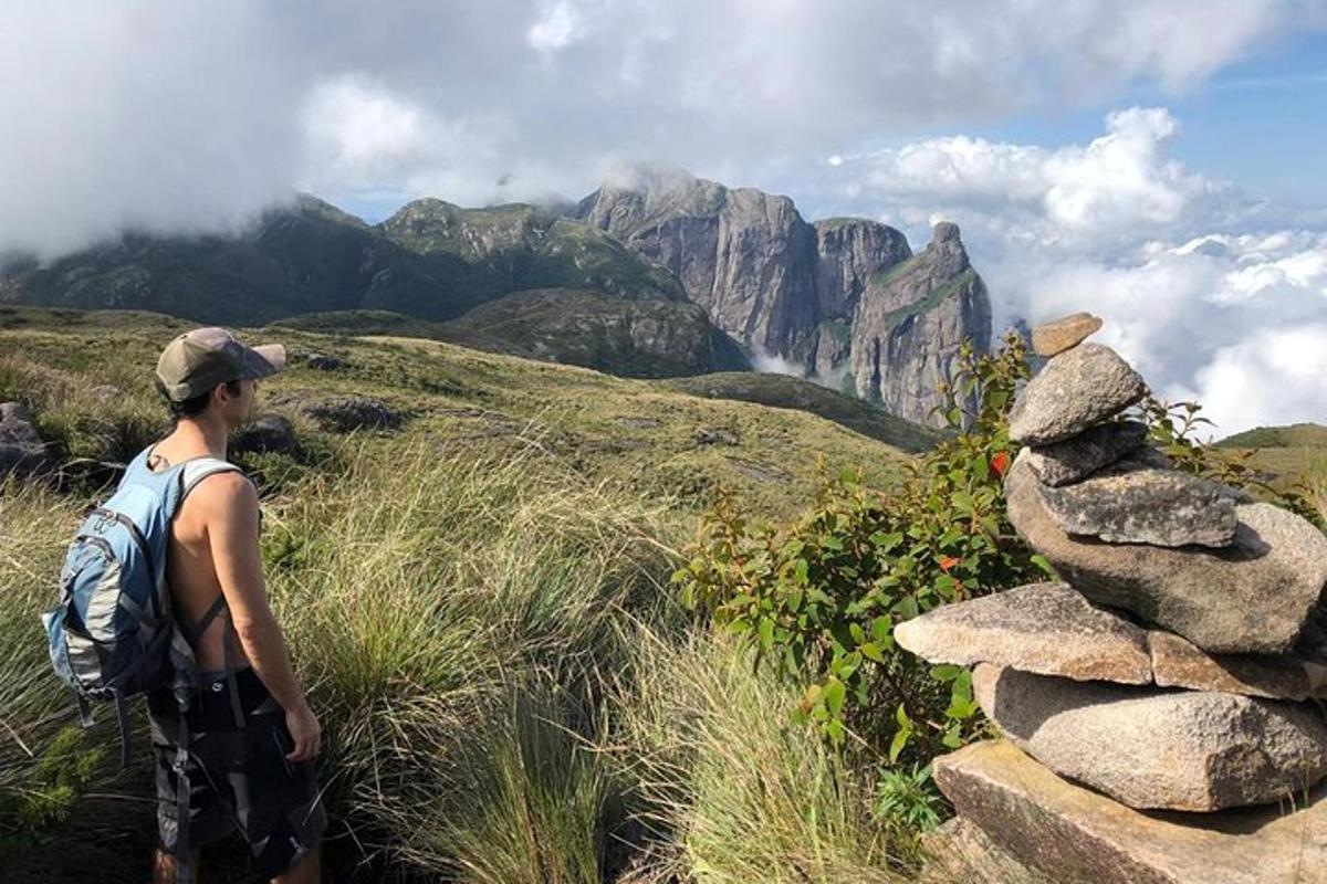 un uomo in piedi su una montagna con un mucchio di rocce