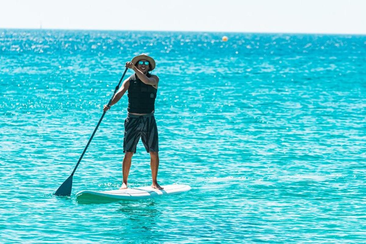 muž stojící na paddleboardu ve vodě