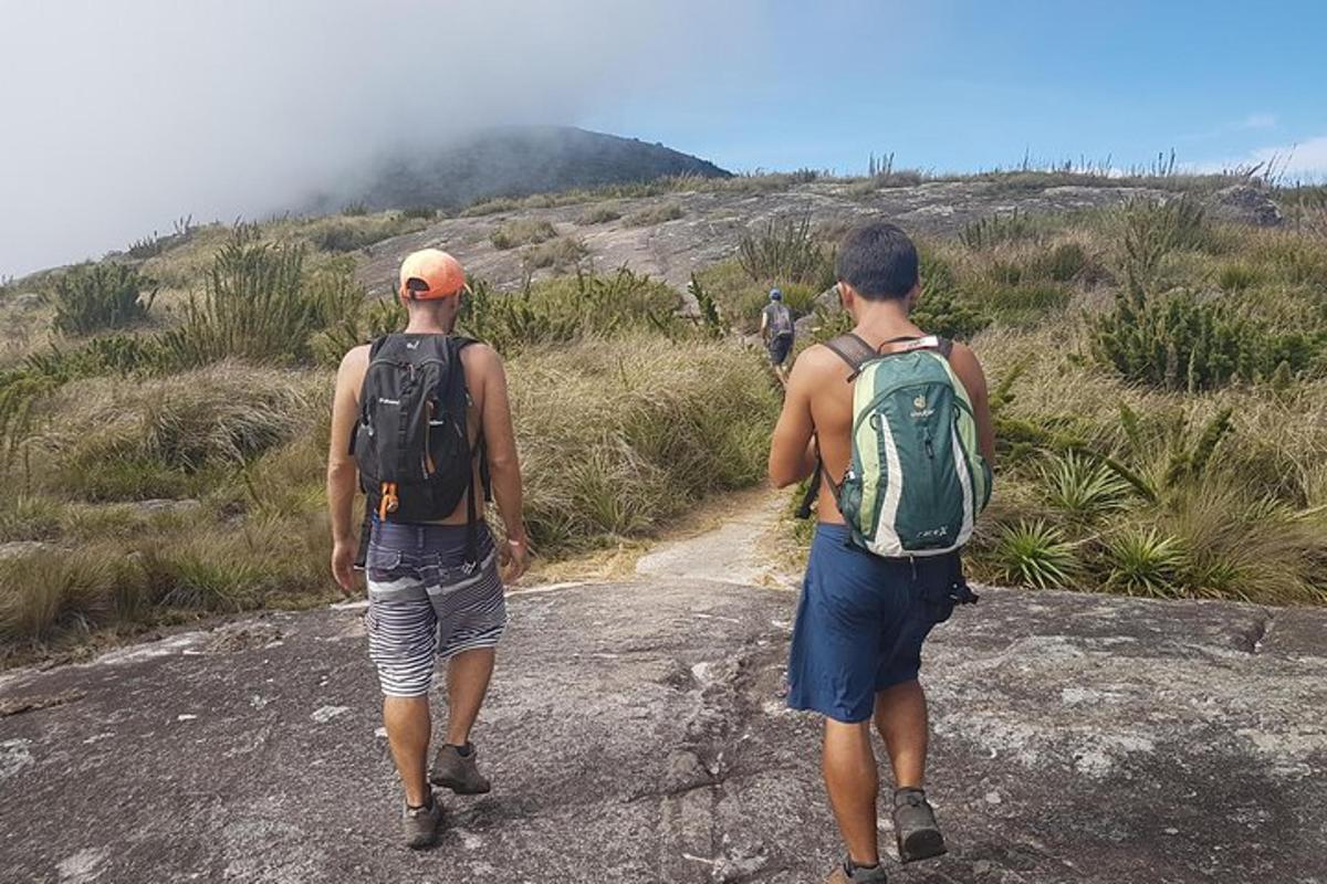 due uomini che camminano lungo una strada sterrata con gli zaini