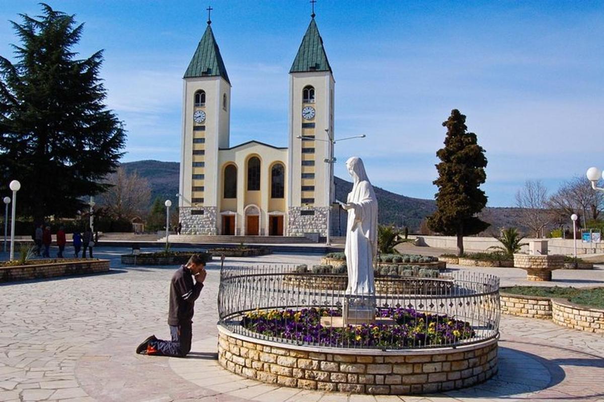 a man taking a picture of a statue in front of a church
