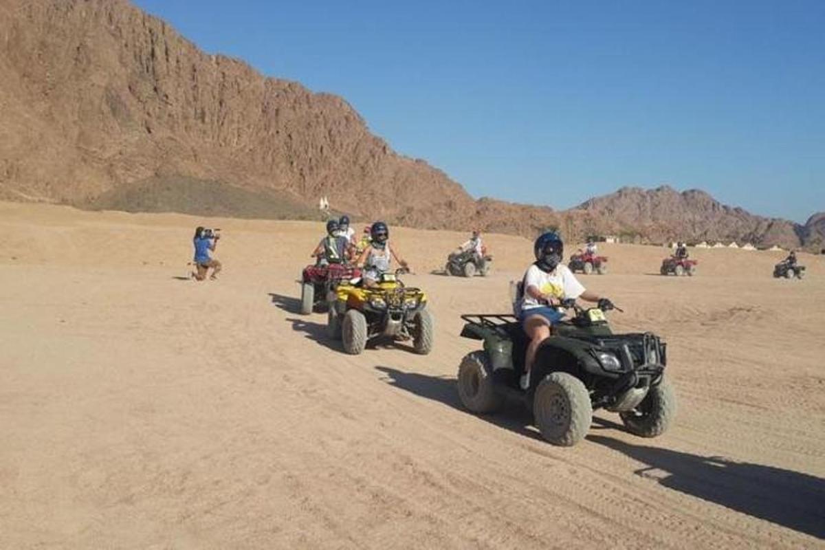 un gruppo di persone in sella a quad nel deserto