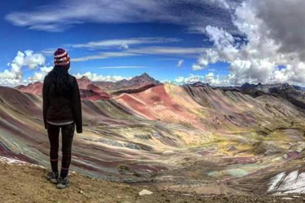una persona in piedi su una collina che guarda un dipinto