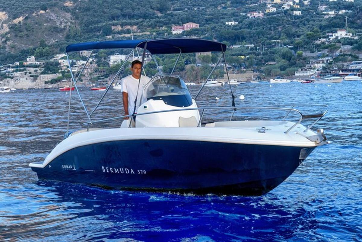 Un hombre está parado en un bote en el agua.