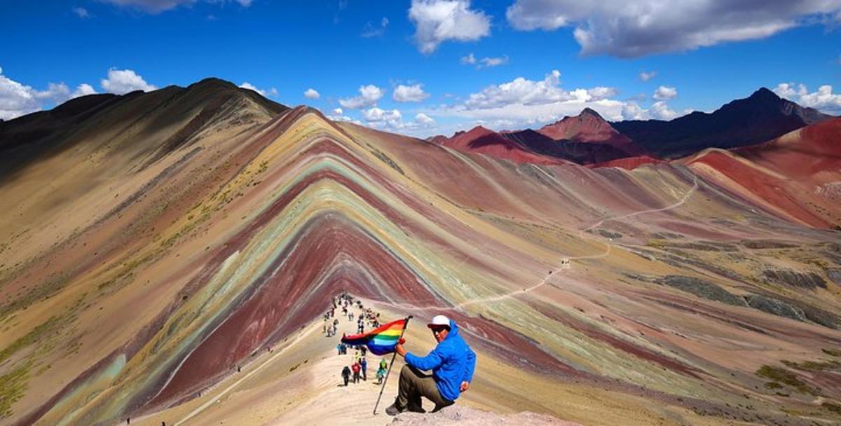 un uomo che tiene un aquilone in cima a una montagna