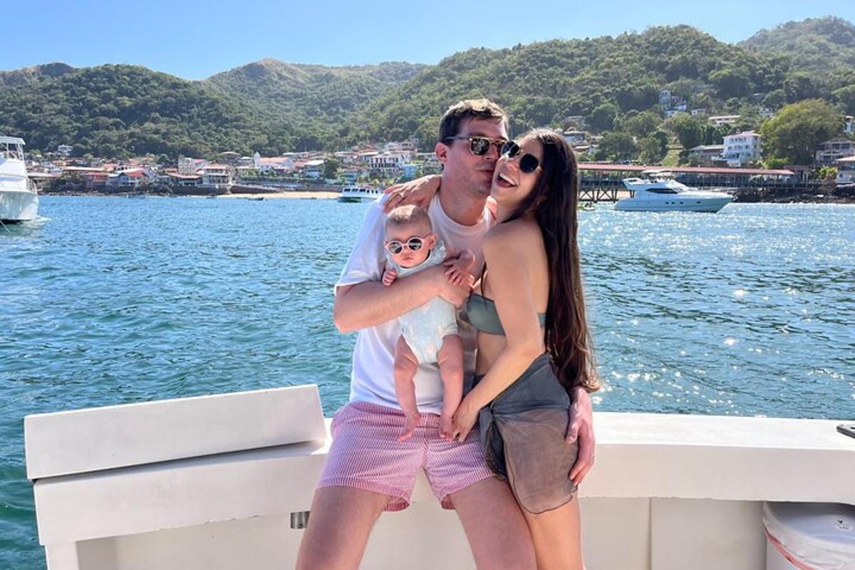 a man and a woman holding a baby on a boat