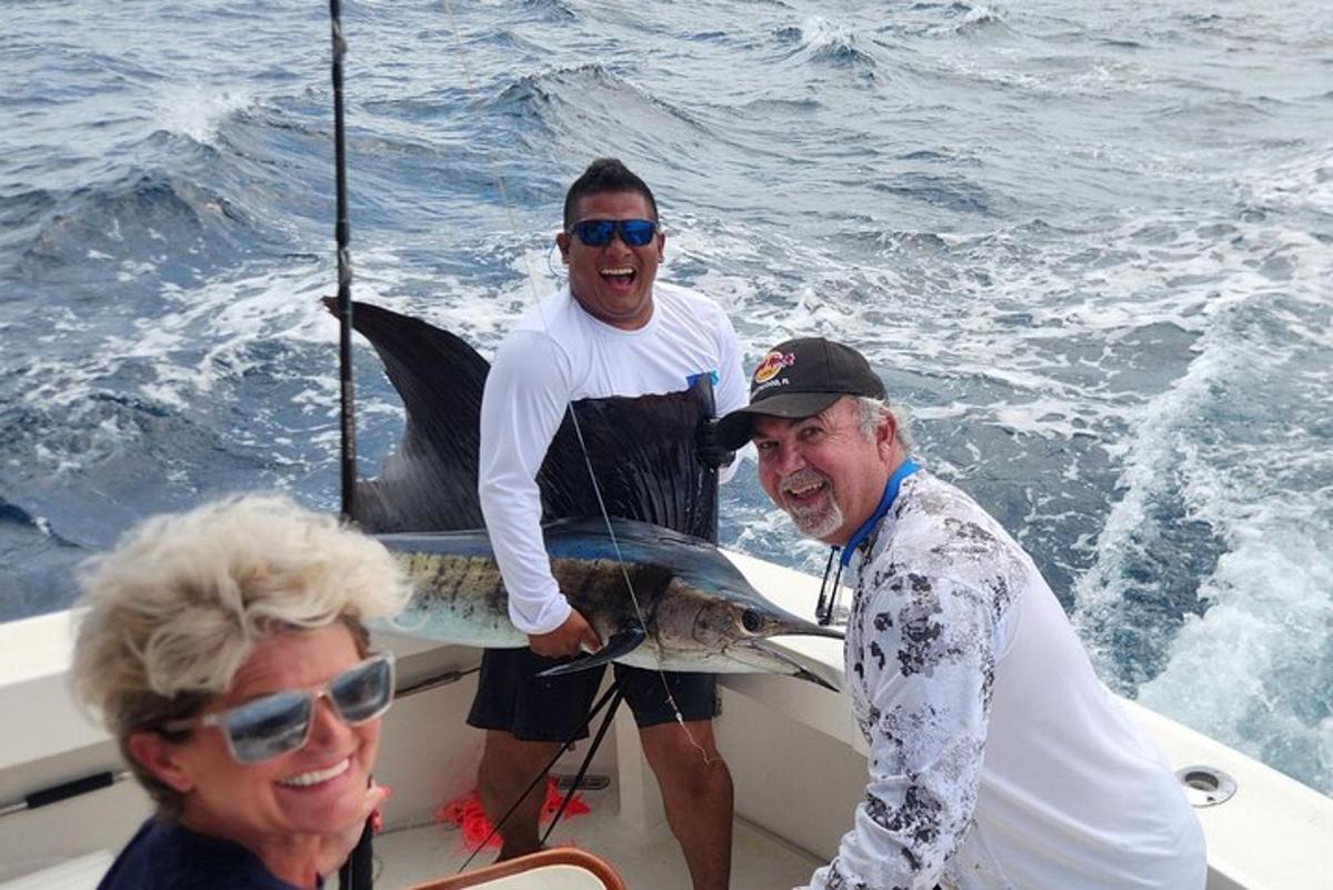 a group of three men on a boat with a fish