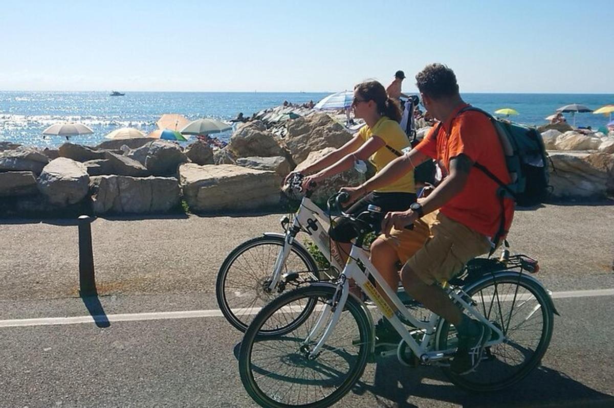 a man and woman riding bikes on the beach