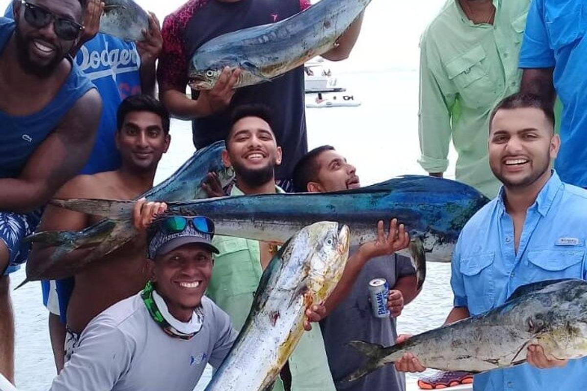 a group of men holding fish in their hands