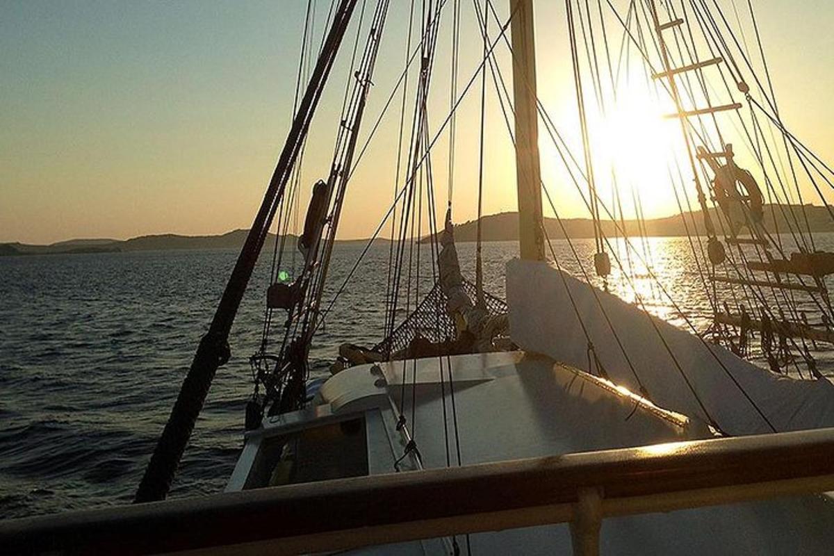 una barca in acqua con il sole che tramonta