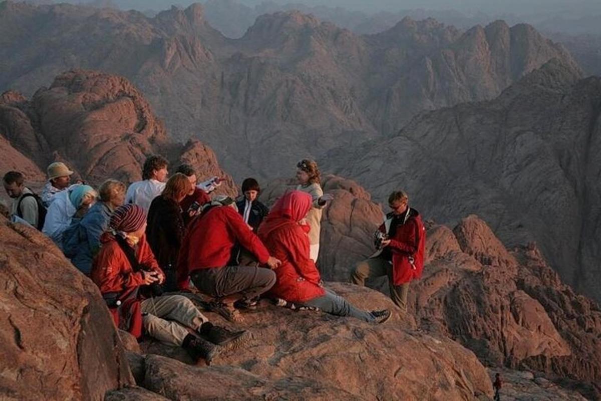 un gruppo di persone sedute in cima a una montagna