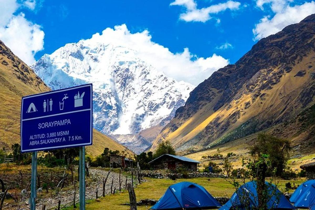 a sign in front of a snow covered mountain