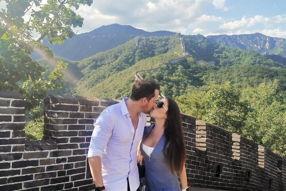 a man and a woman kissing on the great wall
