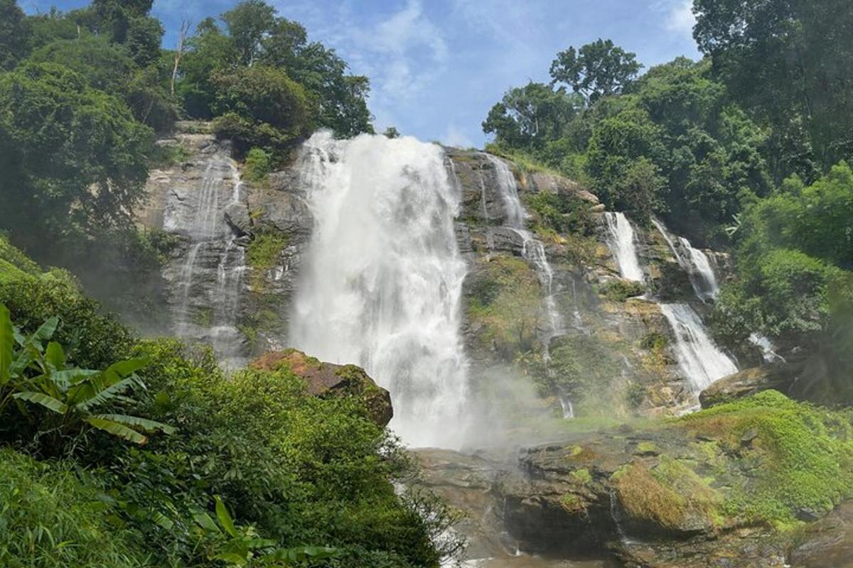 a waterfall in the middle of a mountain with trees