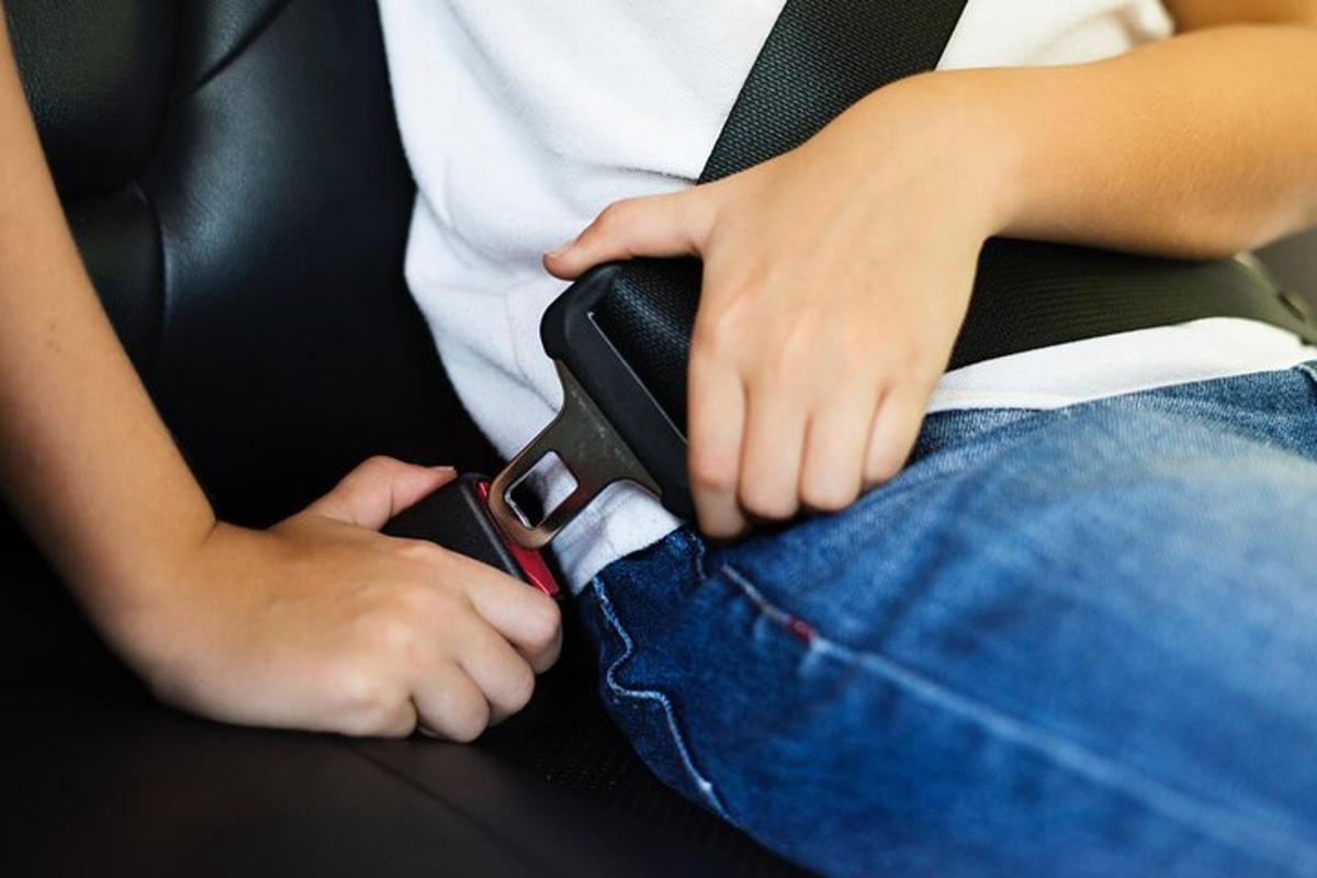 autos istuv inimene, kes hoiab käes mobiiltelefoni