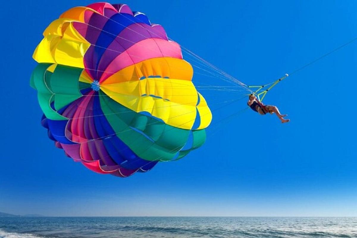 một người đang bay một chiếc dù đầy màu sắc trên đại dương
