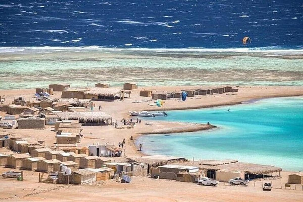 Una playa con un montón de casas y el océano.