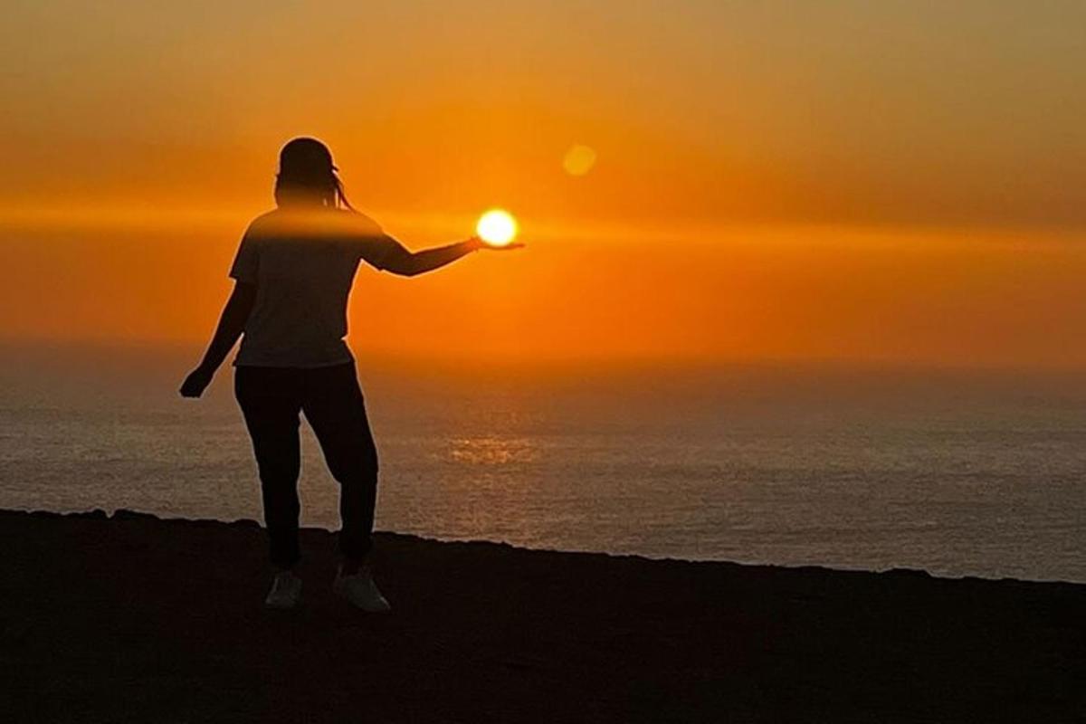 a person standing on the beach watching the sunset