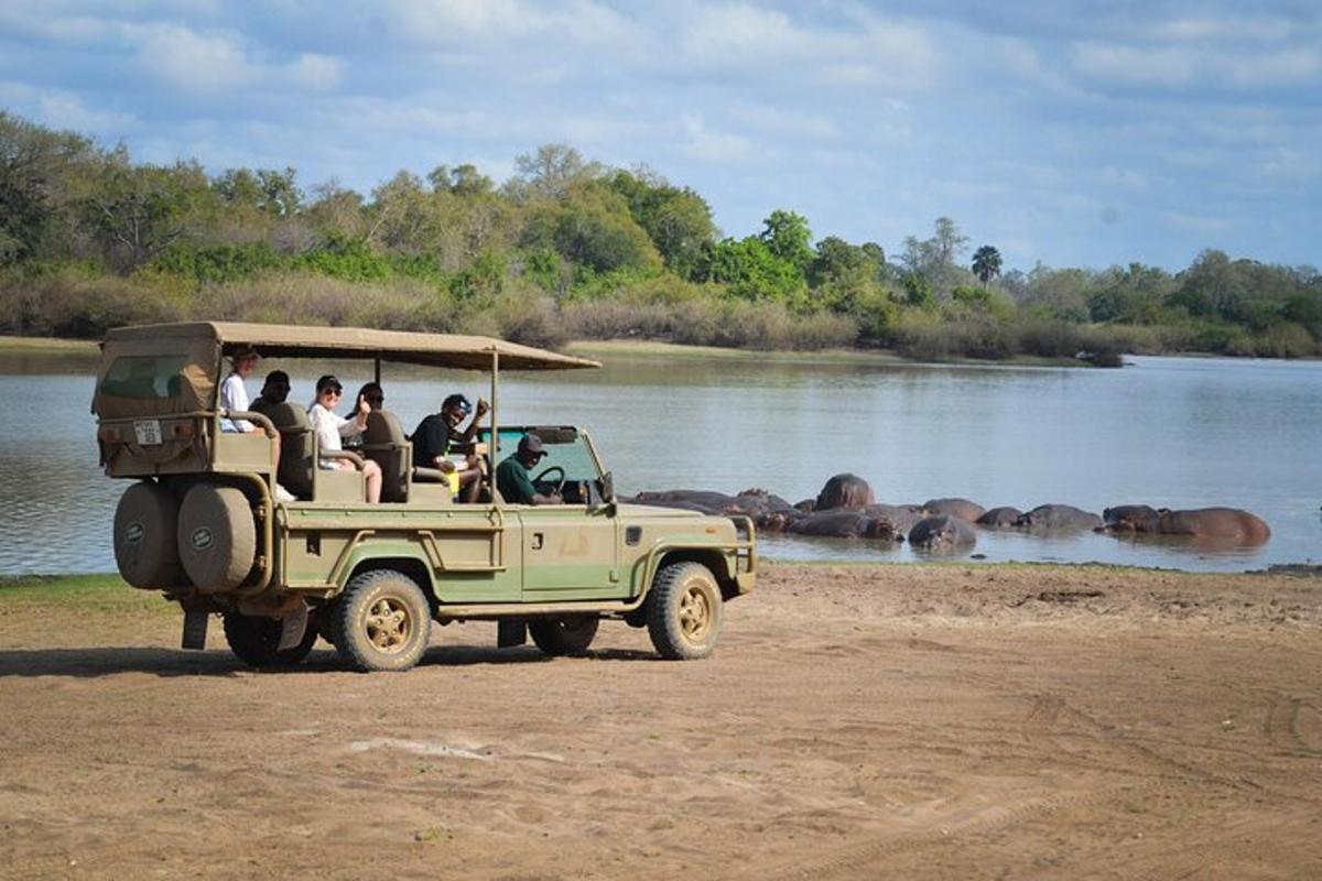 un grup de persones en un jeep per un riu