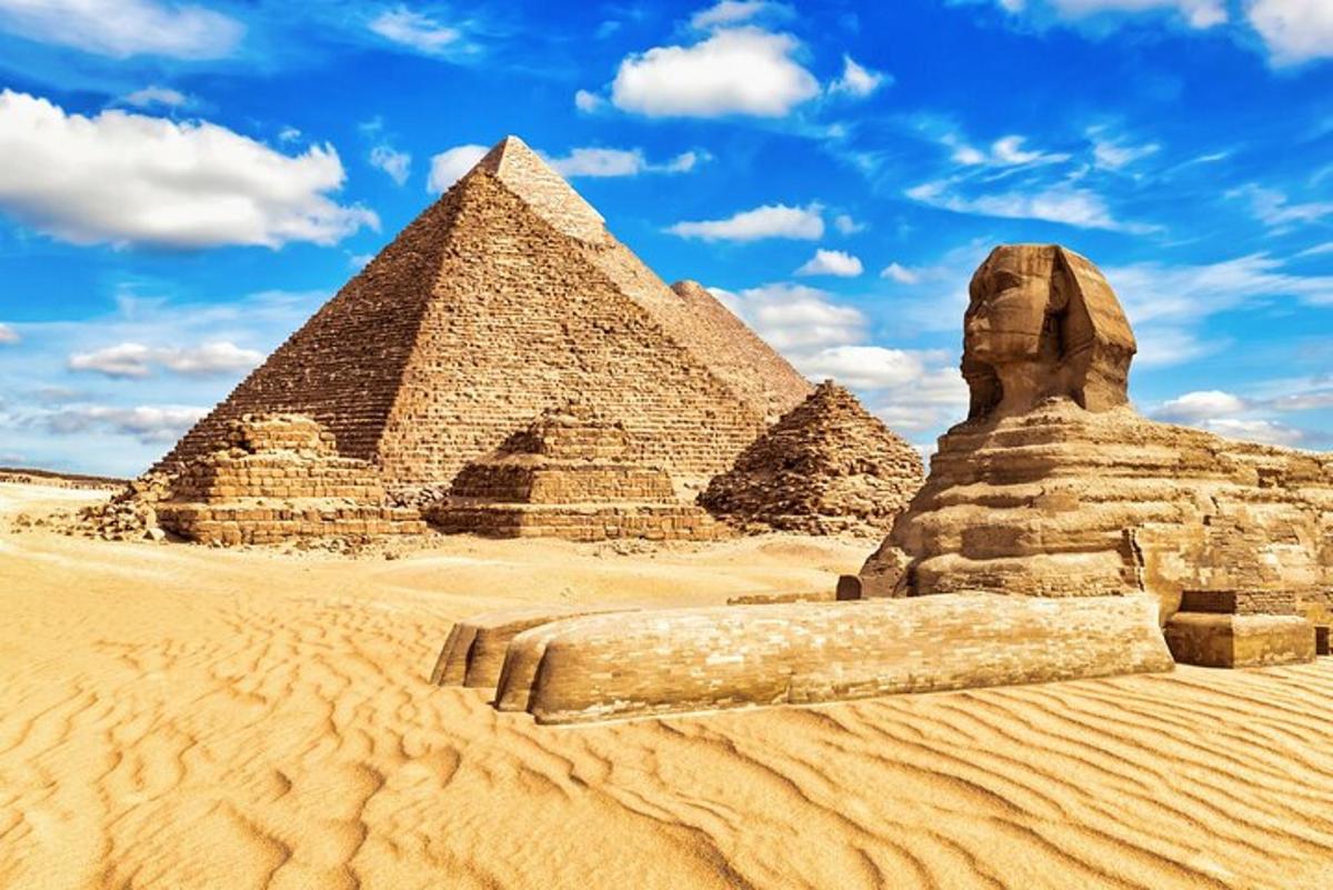 uma vista das pirâmides de Gizé e uma estátua