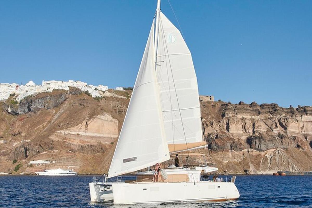 un veler amb una vela blanca sobre una massa d'aigua