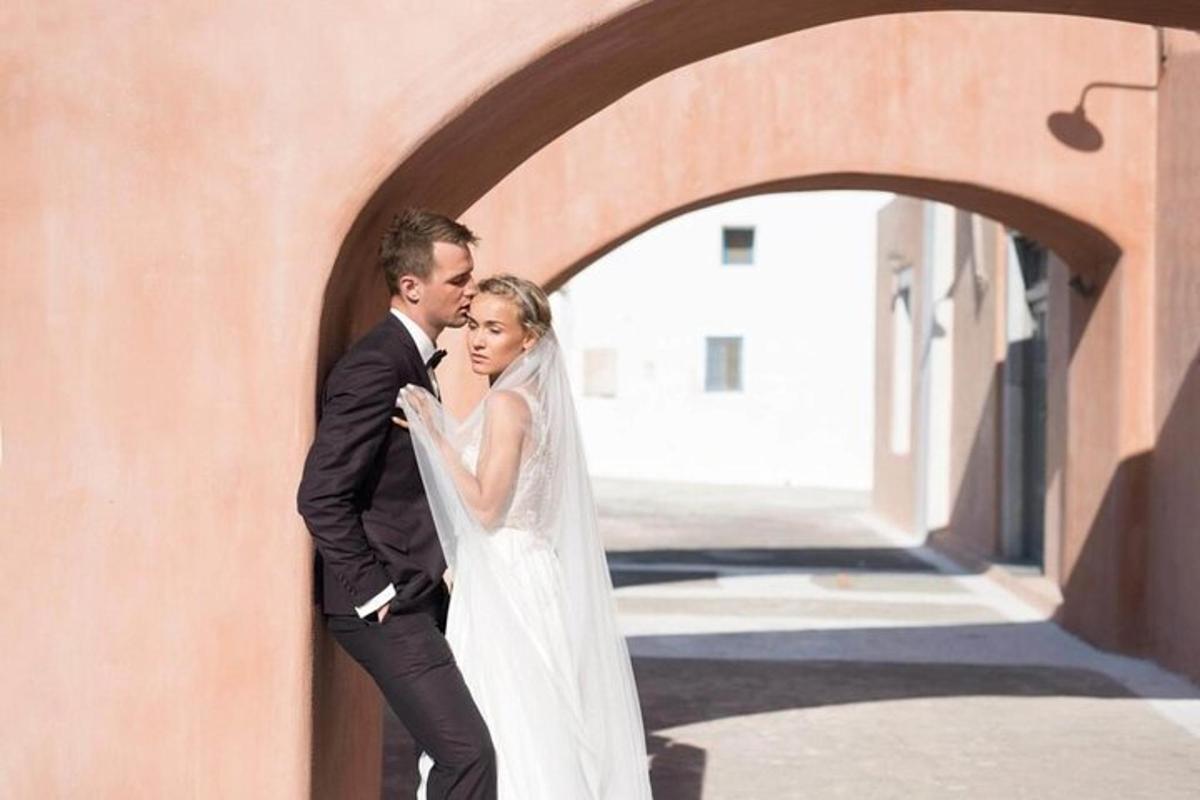 a bride and groom standing next to a wall