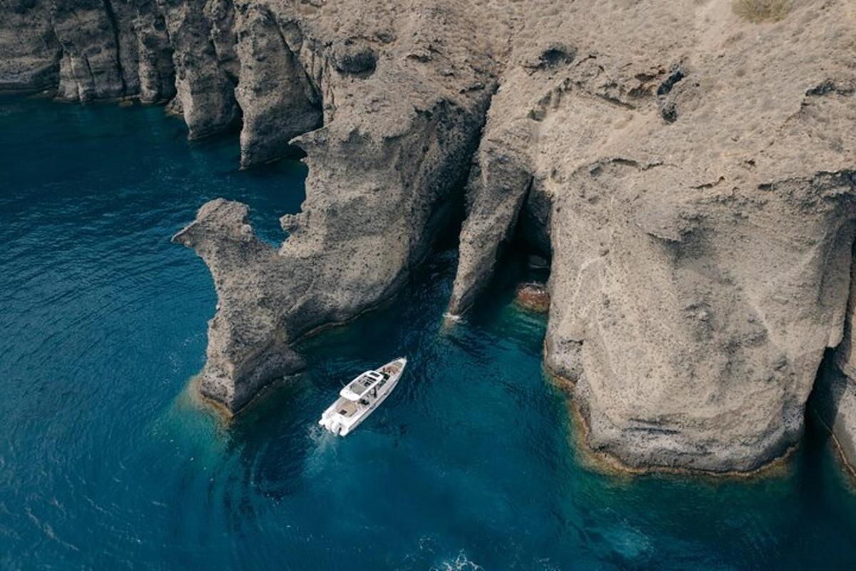un barco en el agua junto a un acantilado