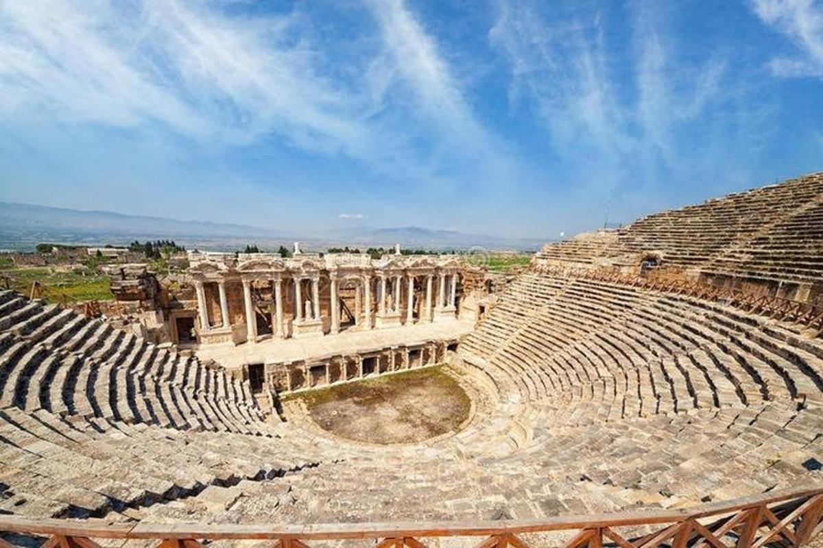 un anfiteatro vuoto con un cielo azzurro sullo sfondo