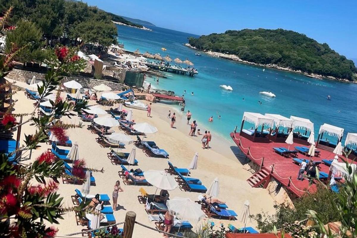 uma praia com um monte de cadeiras e guarda-sóis