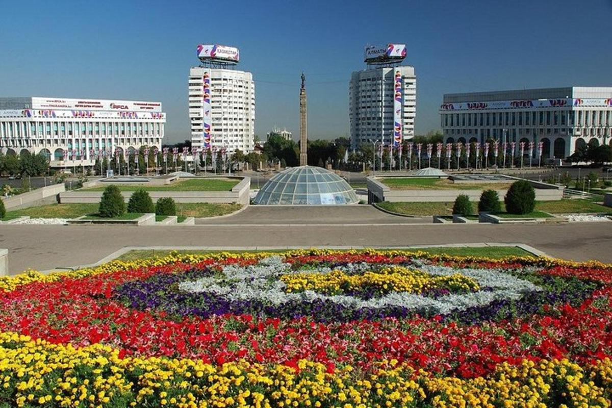 a large flower garden in a city with buildings
