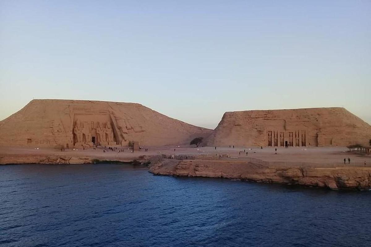 two large sand hills next to a body of water