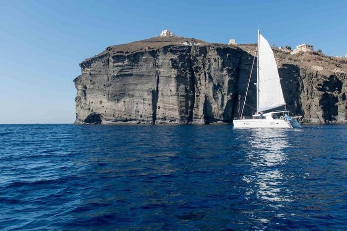 Un velero en el agua cerca de una gran roca