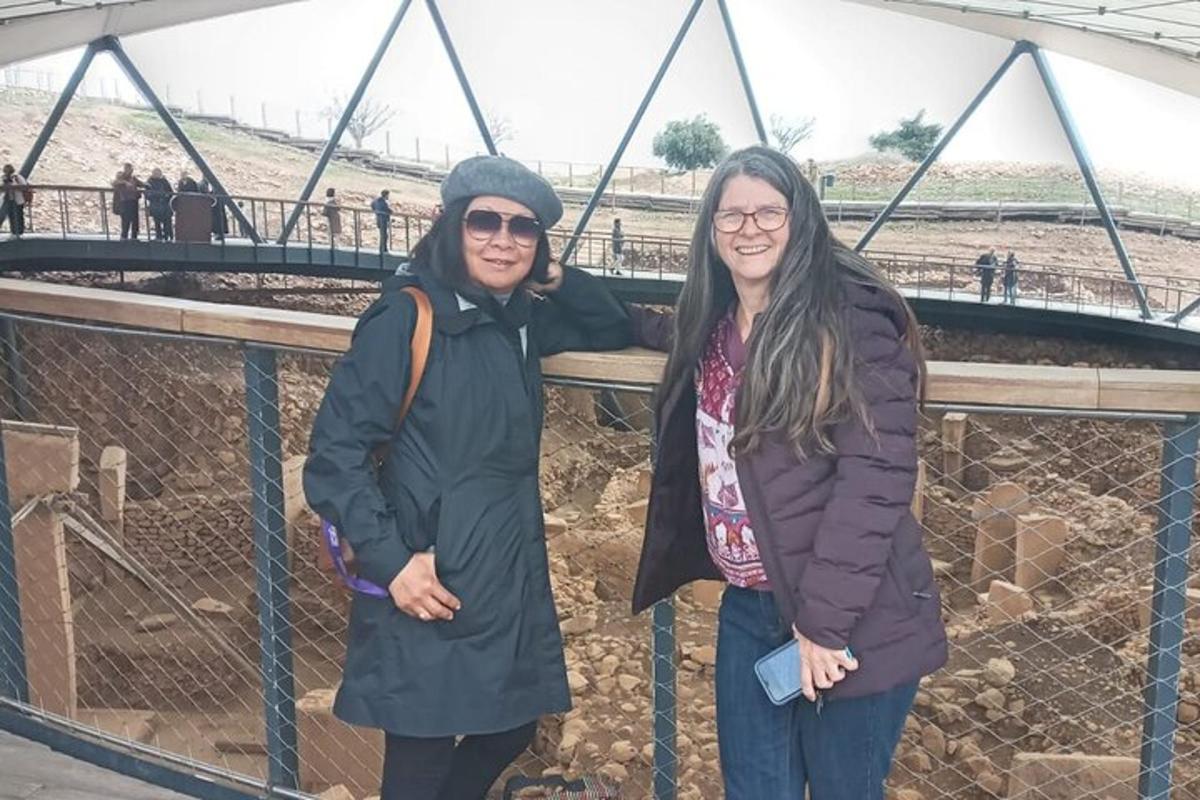duas pessoas em pé uma ao lado da outra em frente a uma ponte
