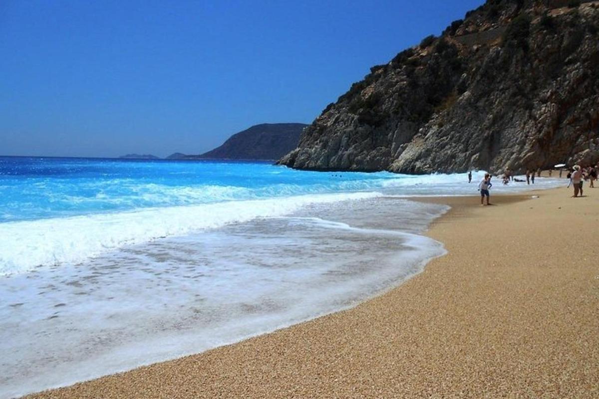 un gruppo di persone che camminano su una spiaggia vicino all'oceano