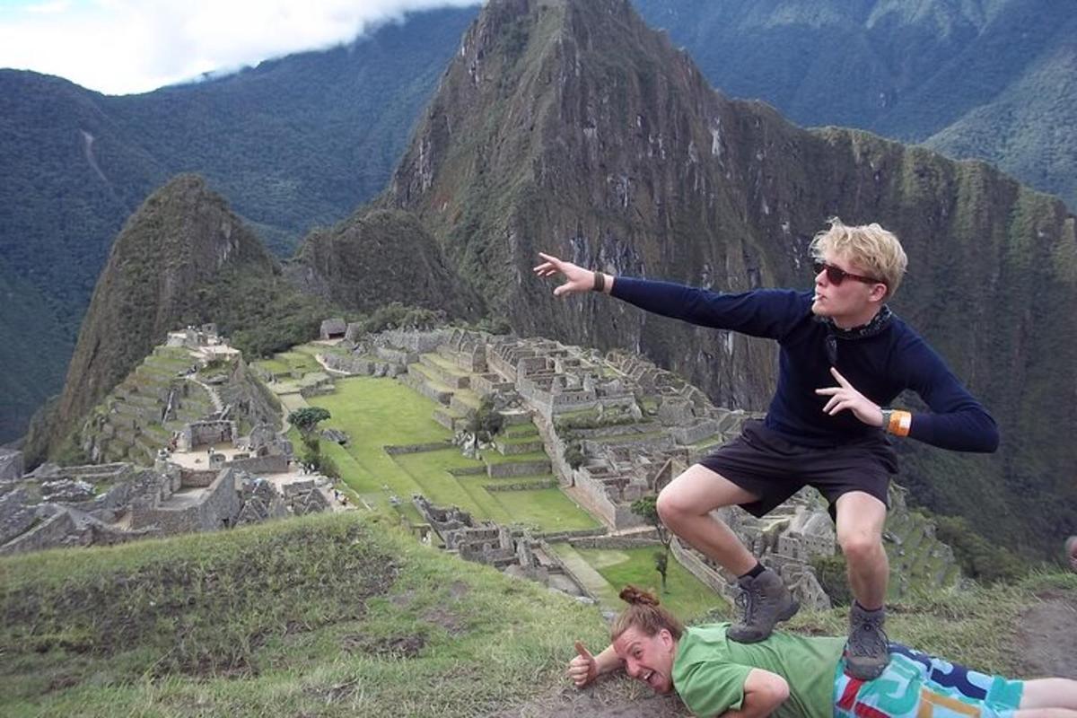 um jovem está pulando no topo de uma montanha