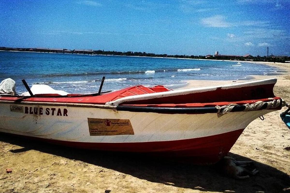 un vaixell vermell i blanc assegut a la platja