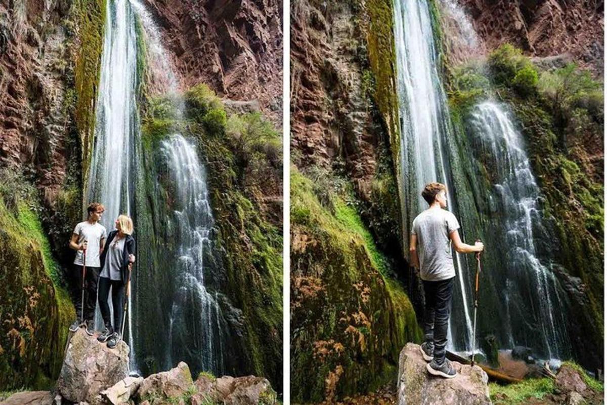 dua orang berdiri di depan air terjun