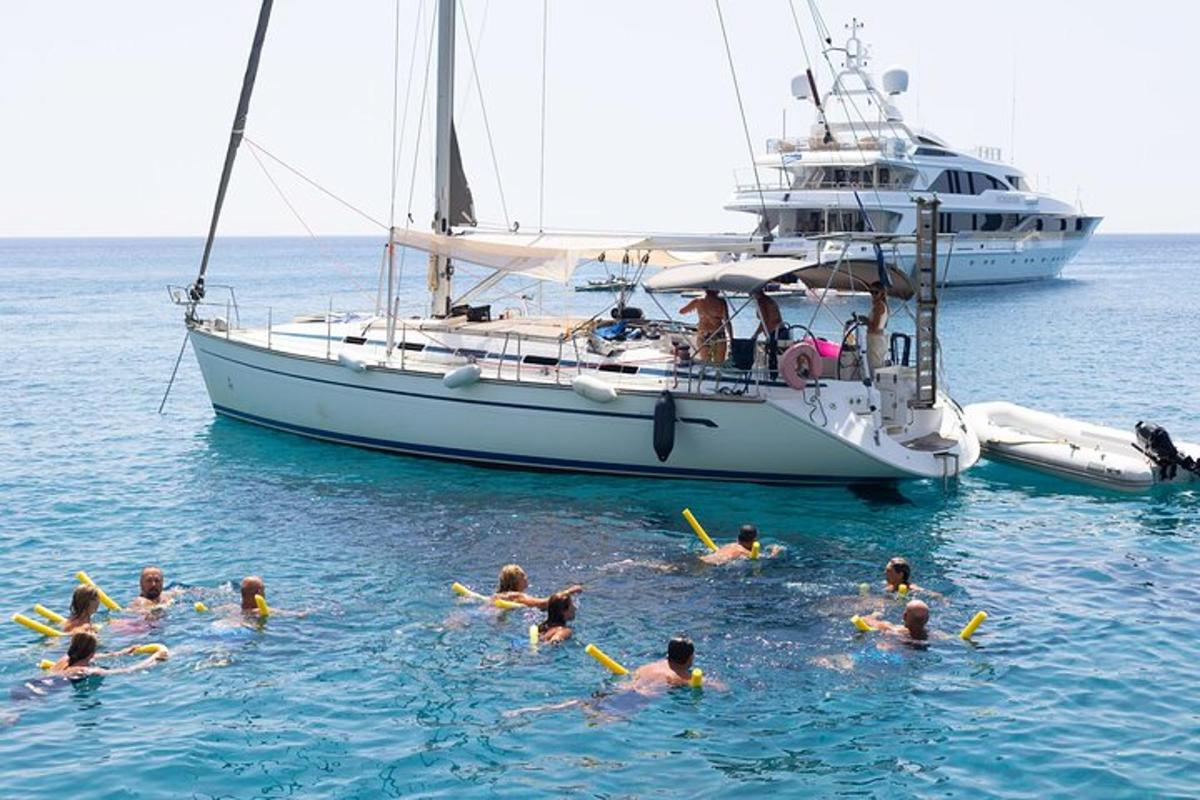 un gruppo di persone che nuotano nell'acqua davanti a una barca