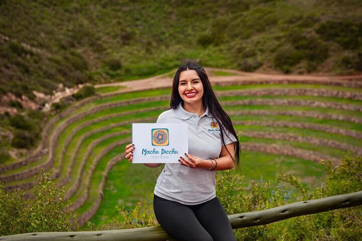 a woman holding a sign in front of a field
