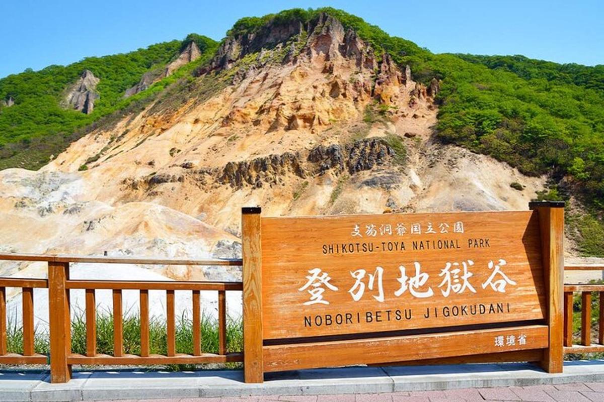 a sign in front of a mountain with a sign